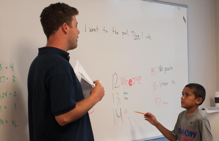 Instructor PJ helps a student with spelling and grammar.