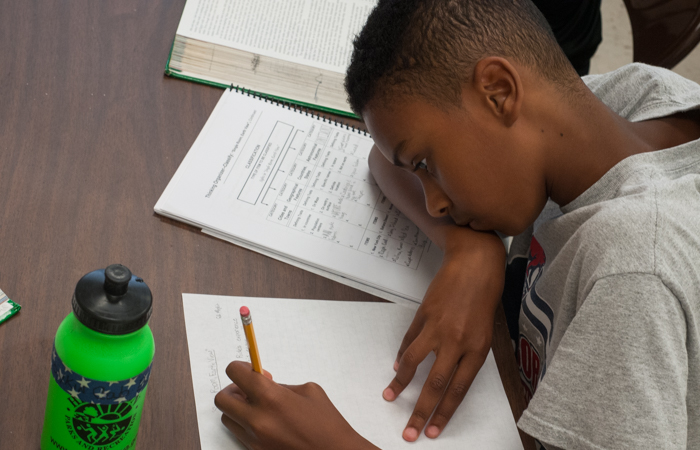 A student works on writing his reading analysis.