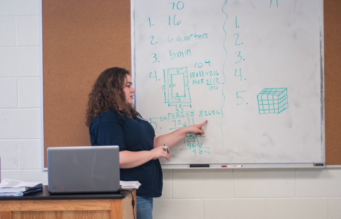An instructor explains a problem using long division.